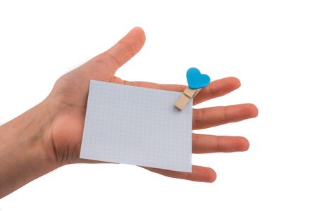 Hand holding a note paper  with a heart on a white backgroundの写真素材