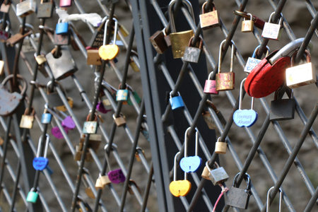 Many colorful metal love padlocks on fence