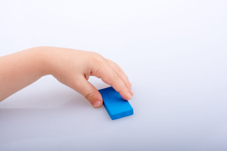 Hand holding color domino on a white backgroundの写真素材