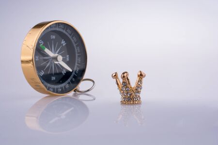 Compass and Golden color crown model with pearls on white backgroundの写真素材