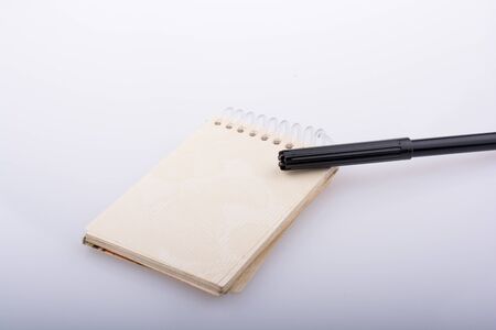 Black color pen on a notebook on a white backgroundの写真素材