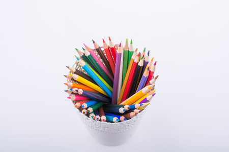 Colorful pencils in a vase on a white background