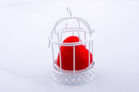 Red heart shape icon in metal wired cageの写真素材
