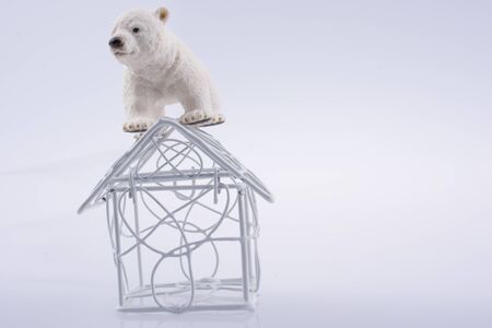 Polar bear cub on the roof of a model house mado of roofの写真素材