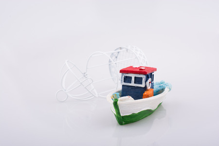 Little colorful model boat with a bird cage on white backgroundの写真素材