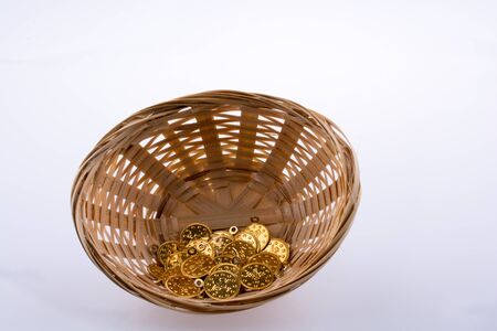 Fake gold color coins placed  in a straw basketの写真素材