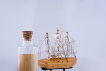 Little bottle and a sailboat on a white background