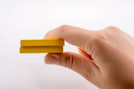 Hand holding yellow color domino pieces in handの写真素材