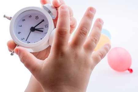 Child  holding an alarm clock  k on white background