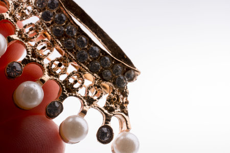 Golden color crown model with pearls on white background