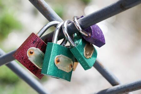 Many colorful metal love padlocks on fenceの写真素材