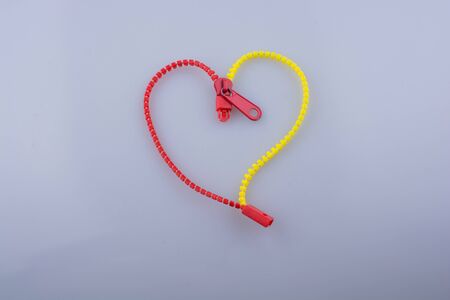 Heart shaped made by the help of a zipper on white backgroundの写真素材