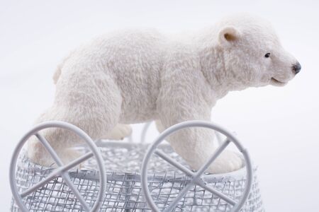 Little  Polar bear figure in a toy  baby carriage  made of metal onの写真素材