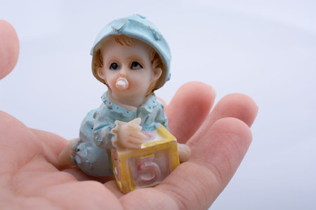Little baby figure in hand on a white background