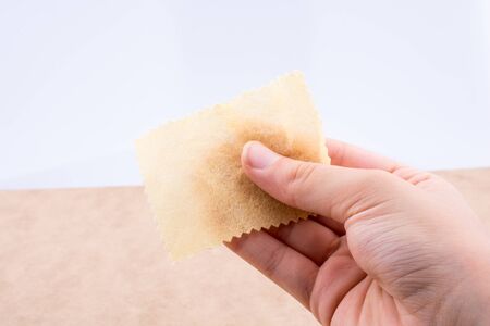 Yellow color mini handkerchief in hand on white backgroundの写真素材