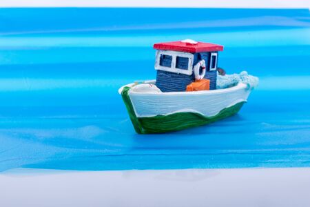 Little colorful model boat with windows on blue backgroundの写真素材