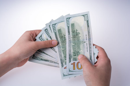 Human hand holding American dollar bill as money isolated on white