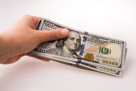 Human hand holding American dollar bill as money isolated on white