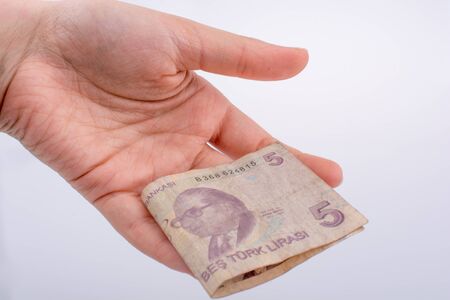Hand holding 5 Turksh Lira banknote  on white backgroundの写真素材