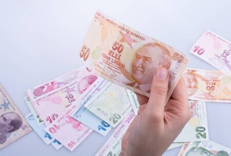 Hand holding Turksh Lira banknotes  on white backgroundの写真素材