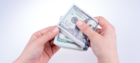 Human hand holding American dollar bill as money isolated on white