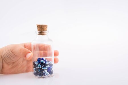 Little  glass bottle  with blue evil eye bead in handの写真素材