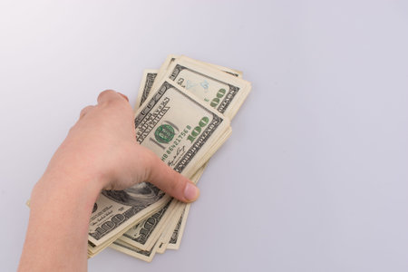 Human hand holding American dollar bill as money isolated on white