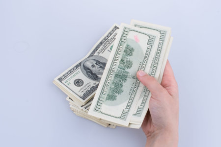 Human hand holding American dollar bill as money isolated on white