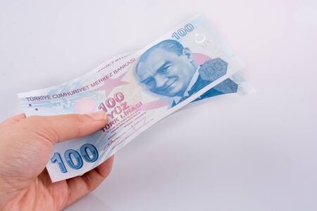 Hand holding 100 Turksh Lira banknotes  on white backgroundの写真素材