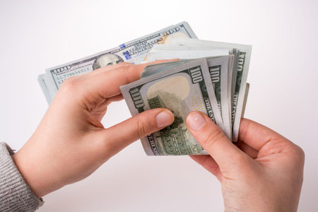 Human hand holding American dollar bill as money isolated on white