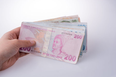 Hand holding Turksh Lira banknotes  on white backgroundの写真素材
