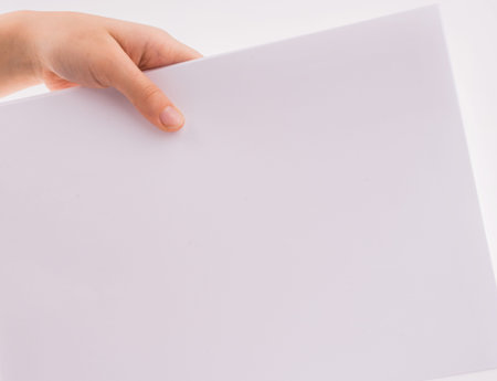 Hand holding a white blank sheet of paper on a white background