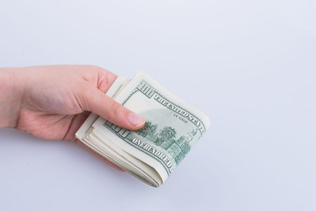 Human hand holding American dollar bill as money isolated on whiteの写真素材
