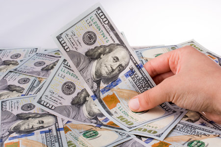 Human hand holding American dollar bill as money isolated on white