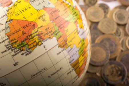 Turkish Lira coins by the side of a model globe on white backgroundの写真素材