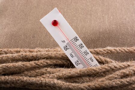 Thermometer placed on a brown rope on a fabric backgroundの写真素材