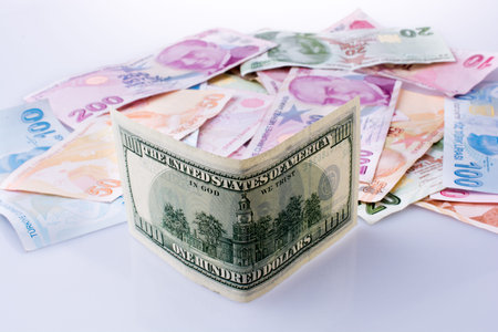 American dollar banknotes and Turksh Lira banknotes side by side on white background