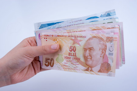Hand holding Turksh Lira banknotes  on white background