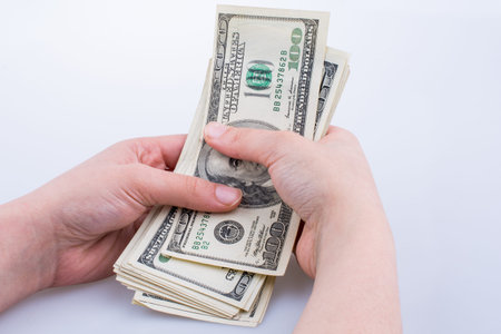 Human hand holding American dollar bill as money isolated on white