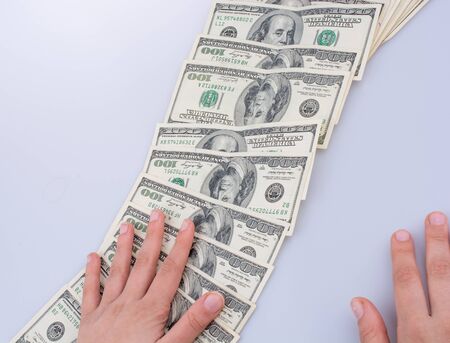 Human hand holding American dollar bill as money isolated on whiteの写真素材