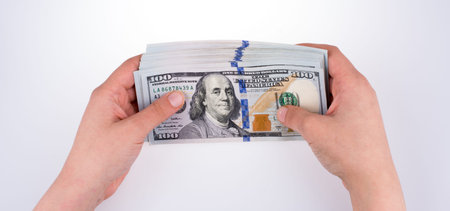 Human hand holding American dollar bill as money isolated on white