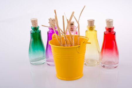 Set of Empty little transparent bottles by the side of a yellow bucketの写真素材