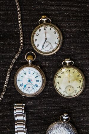 Retro style pocket watch placed on a piece of fabricの写真素材