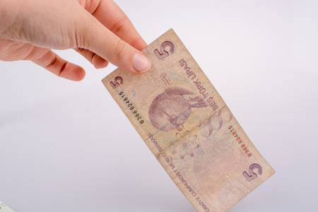 Hand holding 5 Turksh Lira banknote  on white backgroundの写真素材