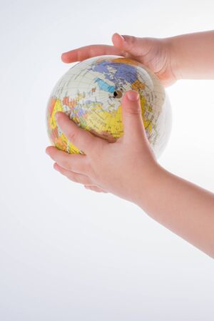 Child holding a globe in on a white backgroundの写真素材