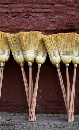 Set of yellow straw broom in a bazaarの写真素材