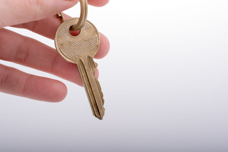 Hand holding a  golden color key in hand