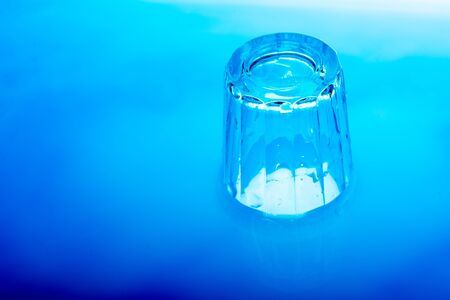 Blue color glass is placed in  blue  color waterの写真素材