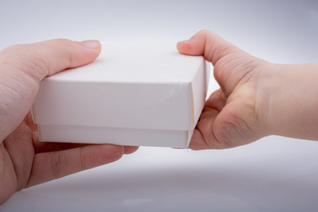 Hand giving a white gift box outの写真素材
