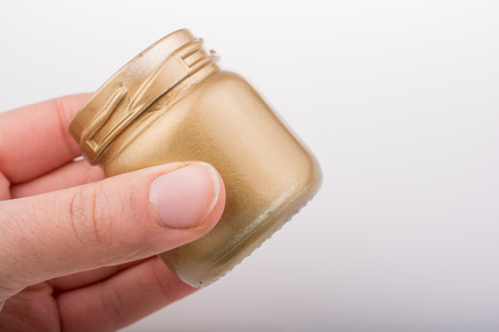 Gold color empty bottle placed on a linen canvasの写真素材